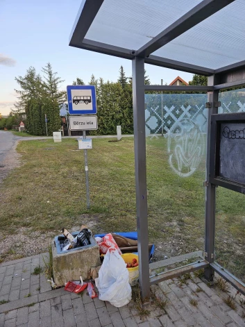 Bērzu ielas autobusu pieturas Mārupē atkritumu urnu kāds apkrāmē ar no sava mājokļa iznestiem sadzīves atkritumu maisiem.