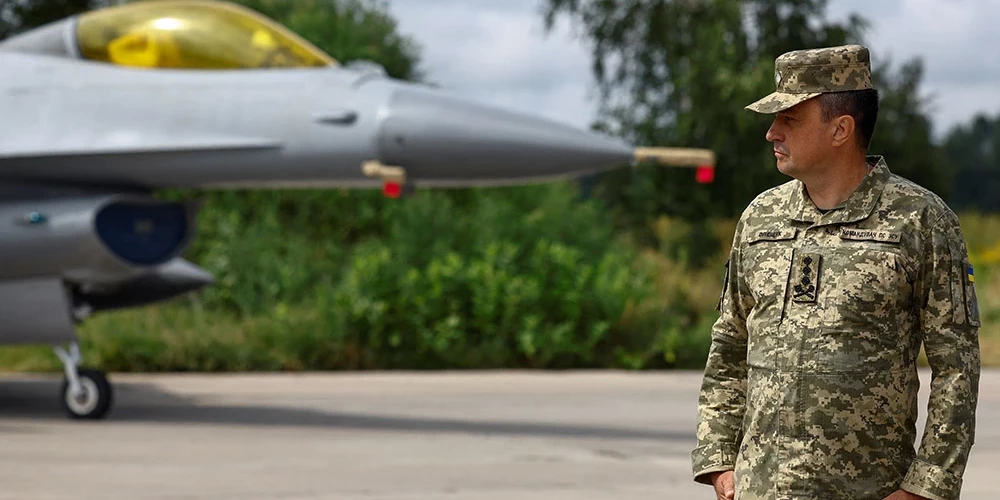 Bijušais Ukrainas Gaisa spēku komandieris Mikola Oleščuks stāv līdzās F-16 iznīcinātājam.
