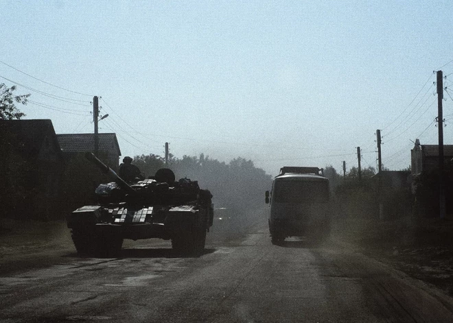 Civilais autobuss Sumu apgabalā brauc garām ukraiņu tankam pa ceļu Junakivkas ciemā, 9 kilometrus no robežas ar Krieviju.