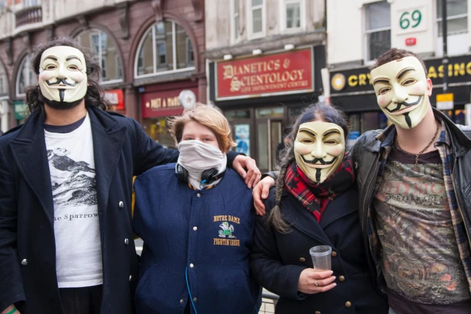 Protesti pret „saentoloģijas kultu” Rietumos reizēm ir visnotaļ atraktīvi (grupa „Anonymous” 2014. gadā protestē pie saentologu biroja Lielbritānijas galvaspilsētā Londonā).