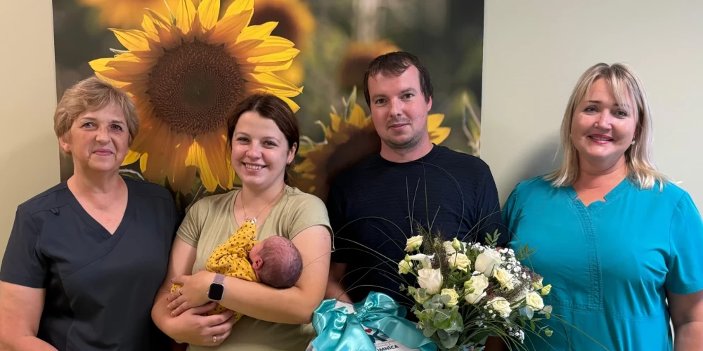 Laimīgie vecāki ar medicīnas darbiniekiem.