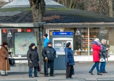 Cilvēki sabiedriskā transporta pieturā. 