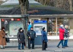 Люди на остановке общественного транспорта в Риге.