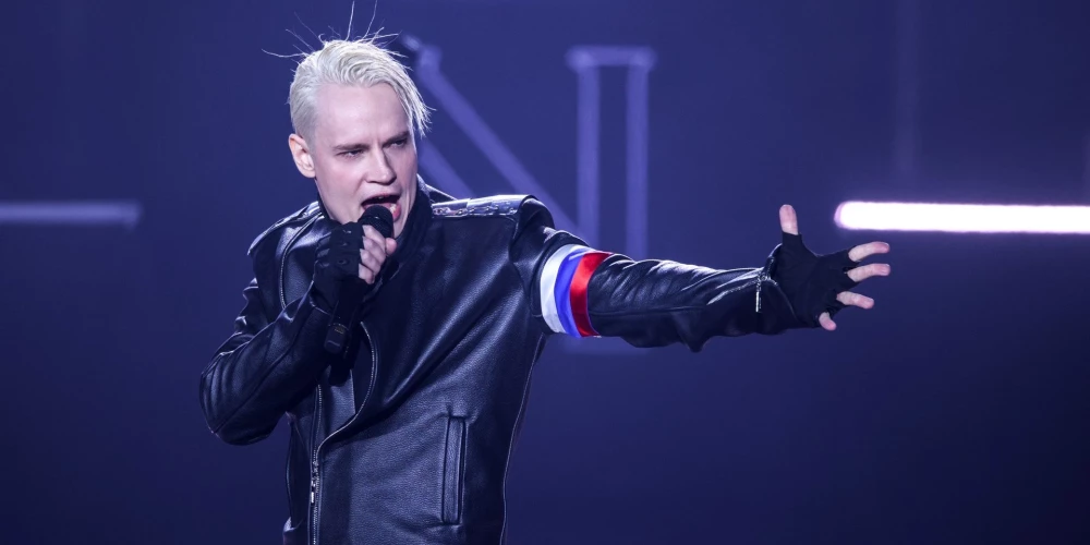 Jaroslavs Dronovs jeb "Shaman" ir 1991. gada 22. novembrī dzimušais krievu dziedātājs, kura slavas laiks sākās reizē ar Krievijas invāziju Ukrainā, viņam kļūstot par jaunās "Z patriotu" paaudzes simbolu. Ar nacionālistiski patriotiskajām dziesmām ("Esmu krievs", "Mana cīņa" utt.) un skatuves tēlu, kas aizdomīgi atgādina Trešā reiha esesieša estētiku, viņš dzimtenē kļuvis par sava veida Horsta Vesela (1907-1930) analogu — galu galā Vesela "Die Fahne hoch" (Pacelt karogus) kļuva par nacistu himnu, un Dronova "Esmu krievs" pretendē kļūt par līdzīgu Kremļa agresijas propagandas ieroci.