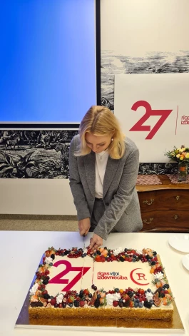 Председатель правления Rīgas Viļņi Айя Шмидре режет праздничный торт.