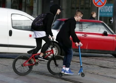 Automašīnas, skrejritenis un riteņbraucējs.