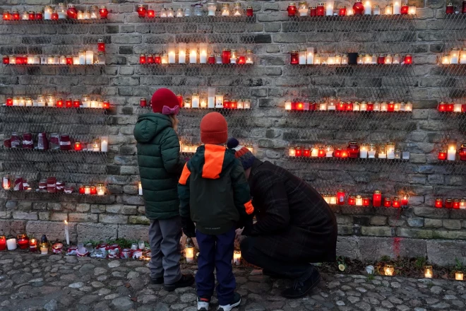 Люди ставят свечи у стены Рижского замка в честь Дня Лачплесиса.