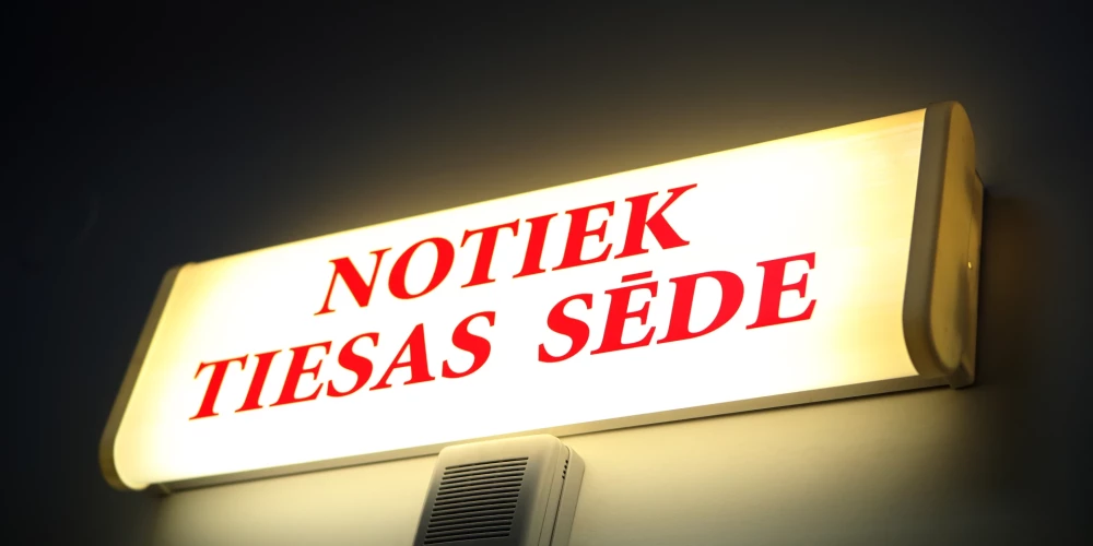 Uzraksts "Notiek tiesas sēde" .