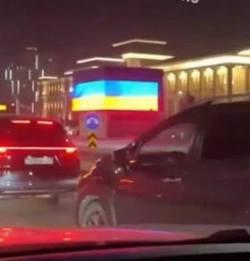 Ekrānuzņēmums no soctīkliem. / Trešdienas vakarā, neilgi pēc tam, kad Putins bija ieradies oficiālā vizītē, uz milzīga ekrāna pie intensīva ceļa Astanas centrālajā daļā parādījās attēls ar plīvojošu zili dzeltenu karogu, redzams sociālajos medijos publicētajos video.