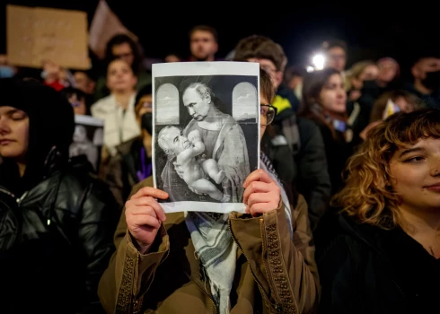 Demonstrante Bukarestē tur plakātu, kur parādīta Kelina Džordžesku saikne ar Kremļa diktatoru Vladimiru Putinu (foto: Scanpix / AP)