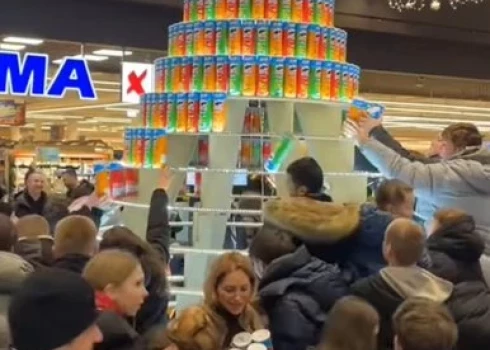 "Akropole Rīga" cilvēki izlaupa no čipsu bundžām izveidotu eglīti.