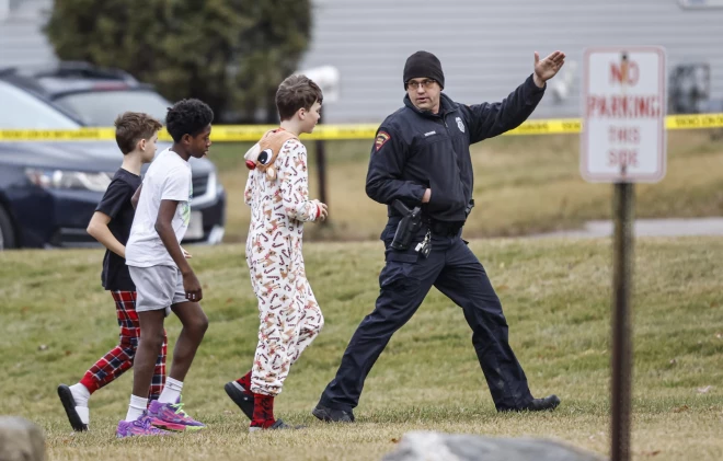 Policists ved “Abundant Life Christian School” skolēnus uz iecirkni.