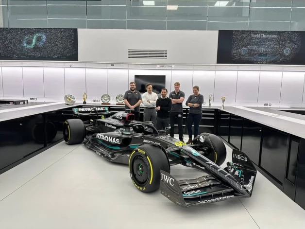 Mārtiņš Zalmans (otrais no kreisās) kopā ar kolēģiem un "Mercedes" F-1 formulu.