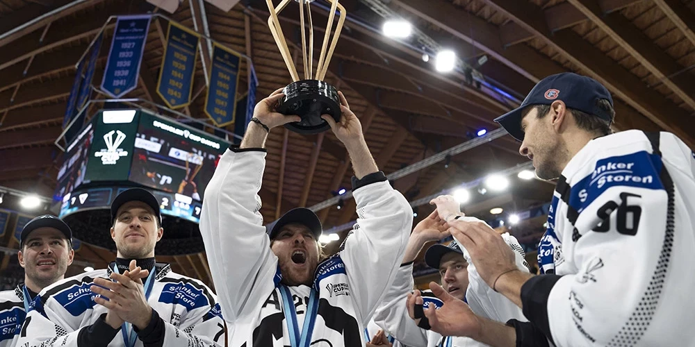 "Fribourg-Gotteron" uzbrucējs Kristofs Berči ar trofeju rokās līksmo par uzvaru Špenglera kausa finālā.