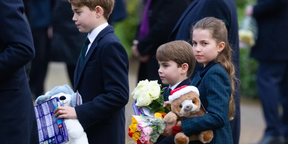 Princim Džordžam, princim Luisam un princesei Šarlotei dāvanu pilnas rokas pēc tikšanās ar tautu Ziemassvētkos.