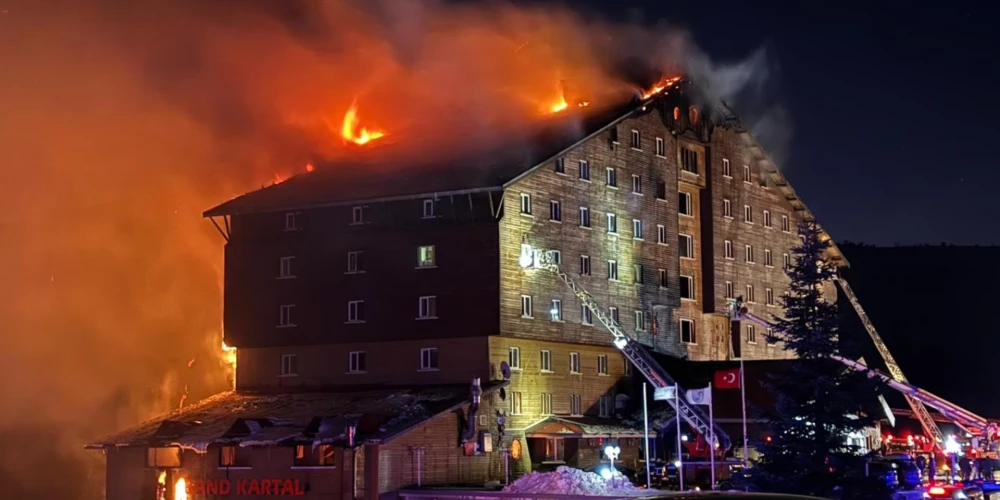 Firefighters work to extinguish a fire in a hotel at a ski resort of Kartalkaya in Bolu province, in northwest Turkey, Tuesday, Jan. 21, 2025. (IHA via AP)  FS101