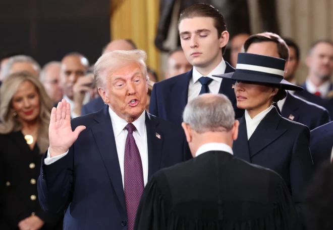 Президент США Дональд Трамп принимает присягу в присутствии Бэррона Трампа и Мелании Трамп в день его инаугурации в Ротонде Капитолия США в Вашингтоне, США, 20 января 2025 года.