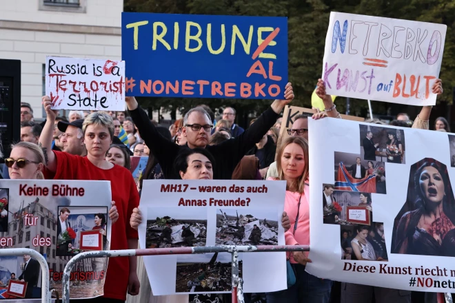 Протестующие держат плакаты во время акции против выступления Анны Нетребко на сцене Берлинской государственной оперы в Берлине, Германия, 15 сентября 2023 года.