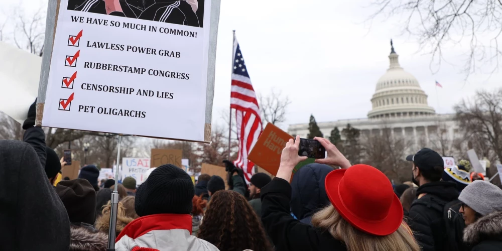 Cilvēki pie Kapitolija Vašingtonā protestē, atbalstot USAID. 2025. gada 5. februāris.