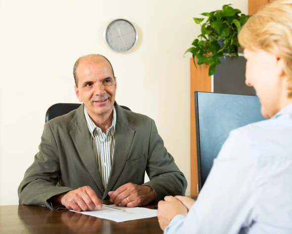Happy client talking with maLatvijā spēkā ir divu veidu testamenti: gan pie notāra apstiprinātie, gan privātie – ar roku rakstītie un mājās, atvilktnē glabātie. nager at notary's office