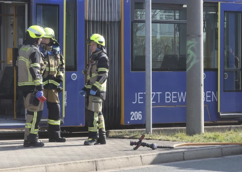 Ugunsdzēsēji pie tramvaja, kur tika aizdedzināta sieviete. 