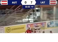 Tablo rāda savādu rezultātu un laiku Latvijas un Austrijas hokeja izlašu spēlē (ekrānuzņēmums no video)