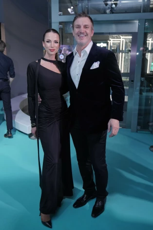 Bijušā hokejista Sanda Ozoliņa sieva Ina Ozoliņa saka: “Izvēlējos vienu no elegantās dizaineres Viktorijas Bekhemas man tīkamākajām drēbēm. Savukārt vīram ir kombinētais uzvalks – samta žakete un smokinga bikses.”