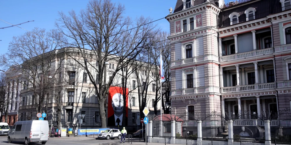 Krievijas vēstniecība Rīgā, kuras ēkai pretim izkārts plakāts ar Krievijas diktatora Vladimira Putina attēlu