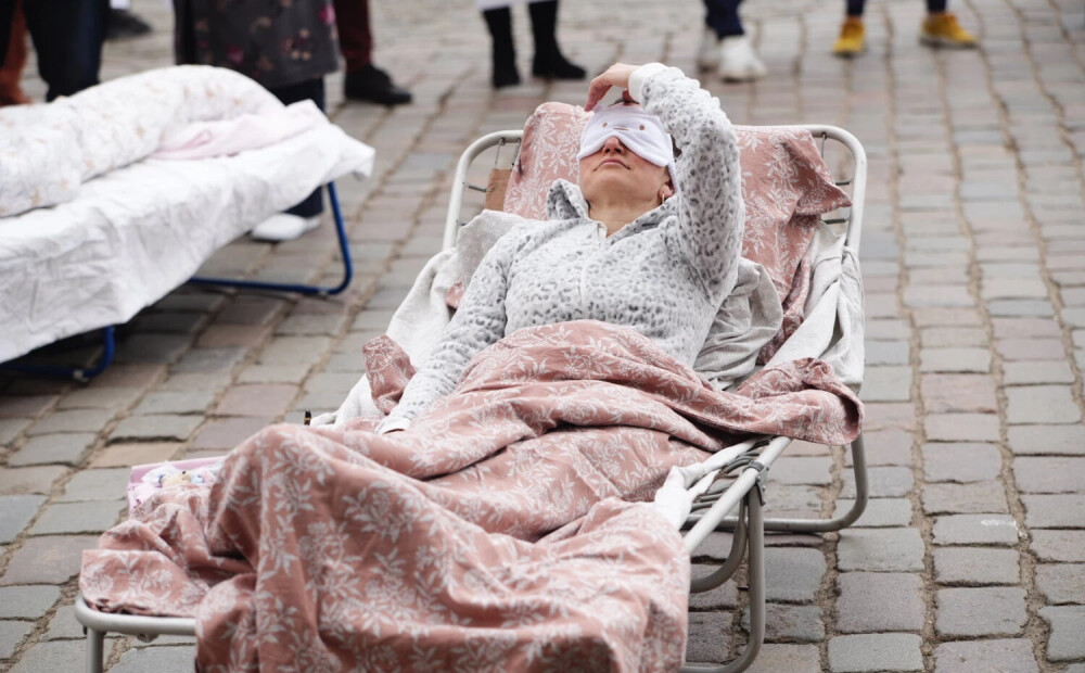 FOTO: "Nakts mieru Rīgai!" Ar gultām Rātslaukumā piketē pret trokšņiem nakts stundās