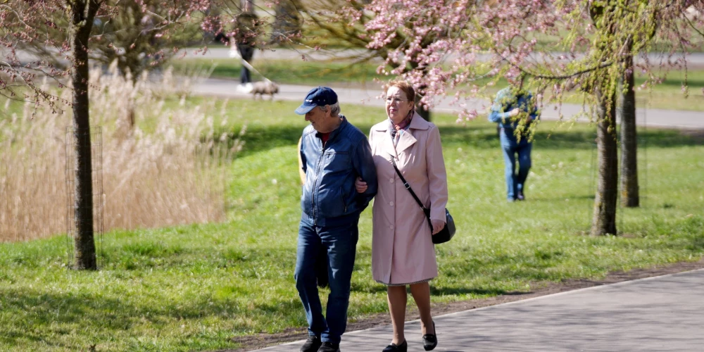 Cilvēki pastaigājas Uzvaras parkā.