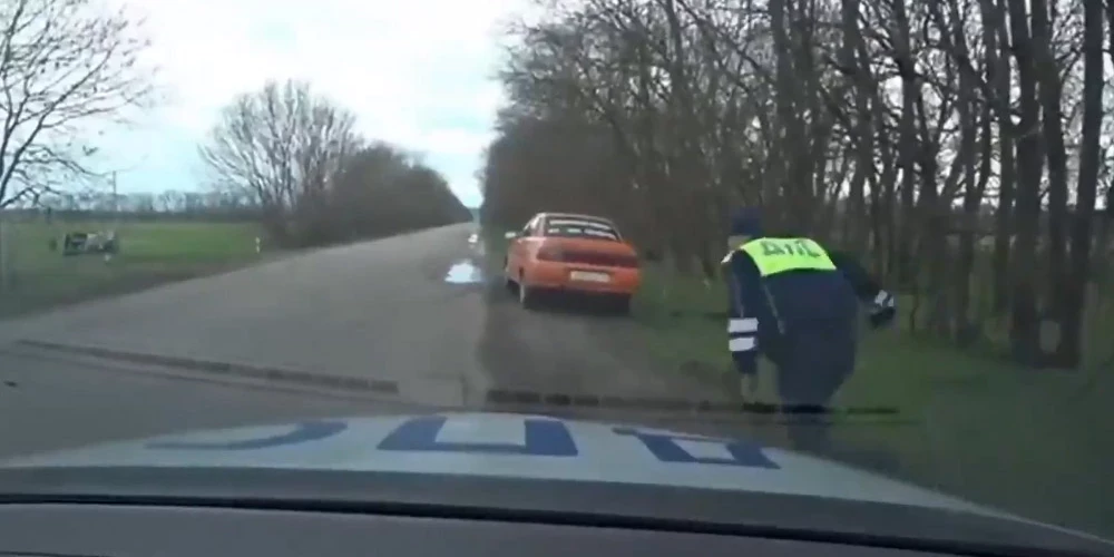 Ceļu policists skrien pie bēgošā autovadītāja un nenojaušs, ka vēl viss nav galā.