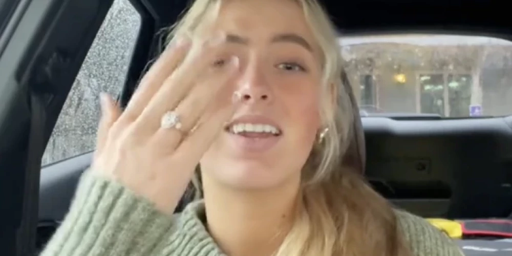 18 gadus vecā jauniete izrāda savu saderināšanās gredzenu.