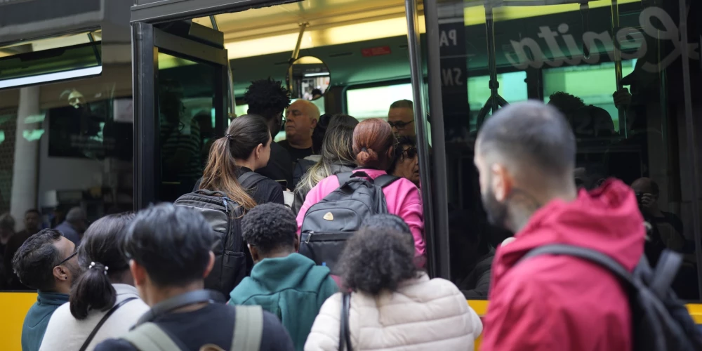 Cilvēki mēģina iekāpt pārpildītā autobusā pēc tam, kad Lisabonā, Portugālē, pirmdien, 2025. gada 28. aprīlī, elektroapgādes traucējumu dēļ tika apturēta metro satiksme.