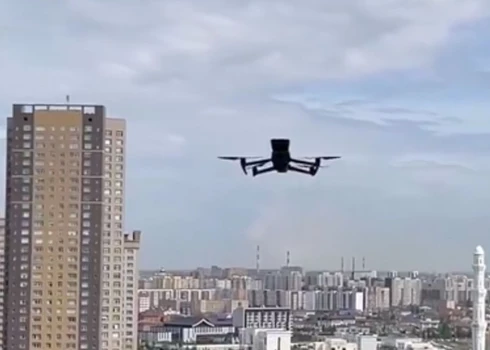 Drons liek aizvērt 20. stāva logu (ekrānuzņēmums no video)