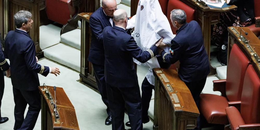 Deputāts Rikardo Madži spoka tērpā tiek izraidīts no Itālijas parlamenta sēžu zāles