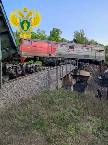 На снимке изображен поврежденный грузовой поезд на месте происшествия после обрушения железнодорожного моста в Курской области, Россия, 1 июня 2025 года.