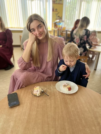 Katrīna Pauniņa un Marks svin ar svētku kūku. Tētis kadrā nav redzams, jo uzņem šo attēlu.