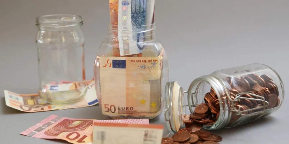 Eiro banknotes un monētas burkā.