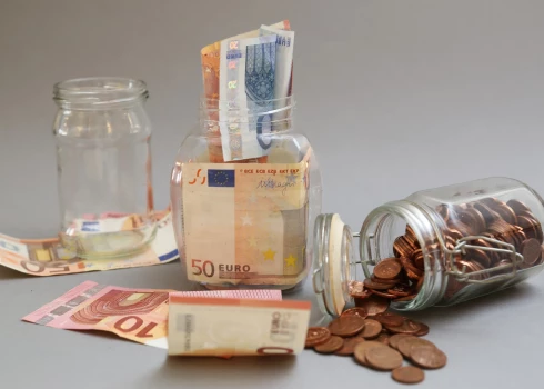 Eiro banknotes un monētas burkā.