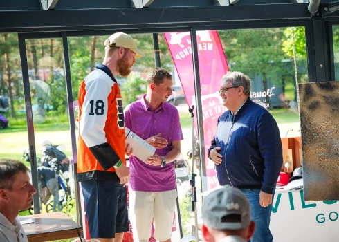 Dāvis Bertāns, labdarības turnīra rīkotājs Kārlis Eniņš un dziedātājs Žoržs Siksna izsolē.