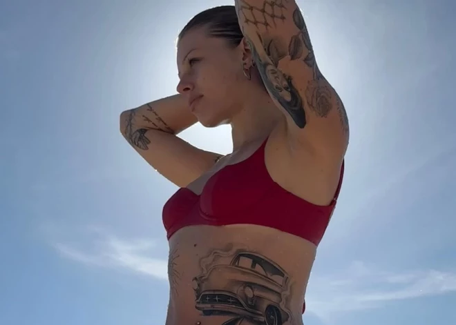 Slavenu vecāku meita, ģērbusies bikini, izrāda savus tetovējumus. Vai vari uzminēt, kurš rokmūziķis ir viņas tēvs?