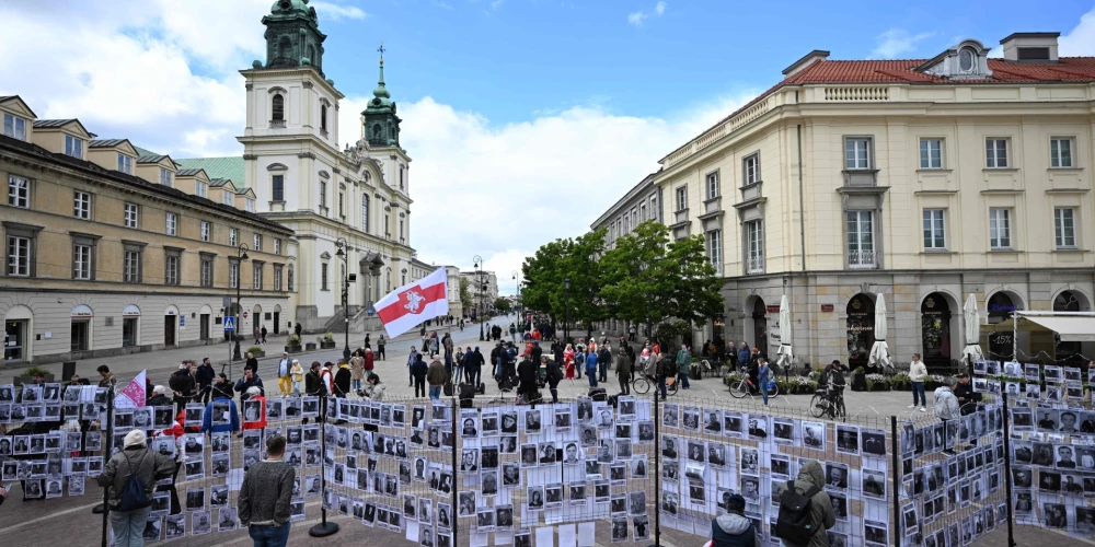 Cilvēki apmeklē izstādi ar Baltkrievijas politieslodzīto portretiem.