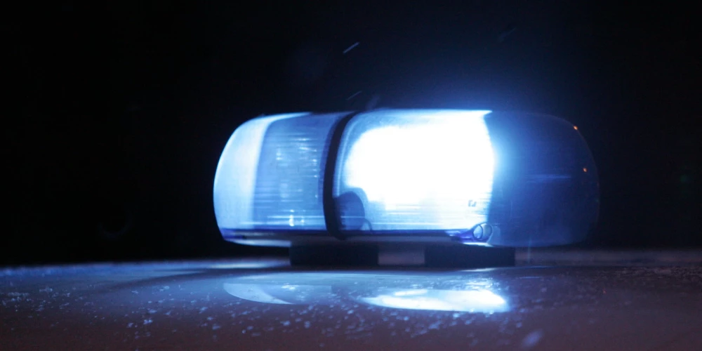 Policijas automašīna ar ieslēgtām bākugunīm.