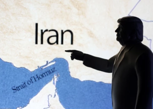 A map showing the Strait of Hormuz and Iran is seen behind a 3D printed miniature of U.S. President Donald Trump in this illustration taken June 22, 2025. REUTERS/Dado Ruvic/Illustration