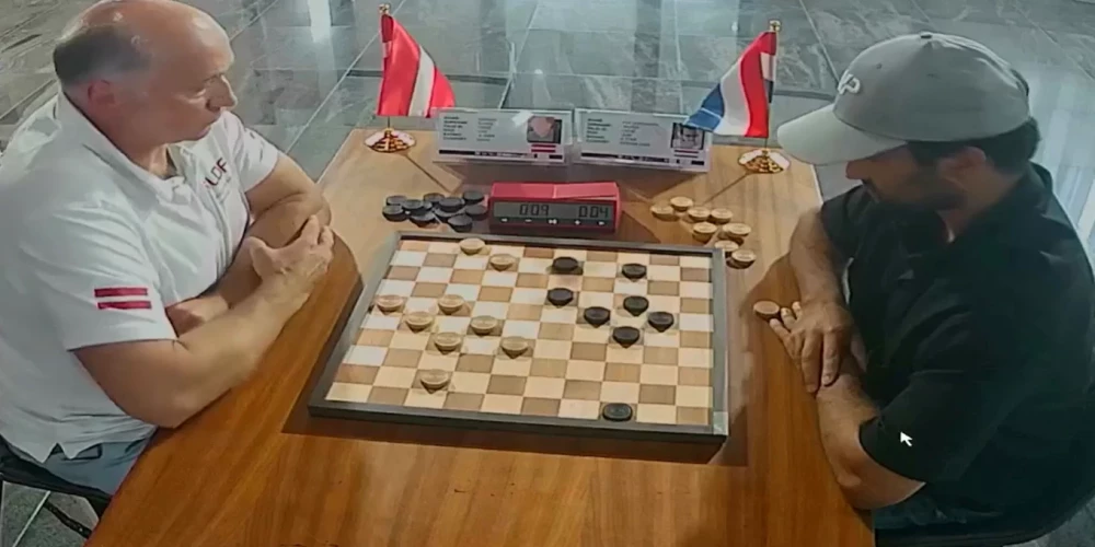 Guntis Valneris (pa kreisi) pasaules čempionātā simtlauciņu dambretē (ekrānuzņēmums no video)
