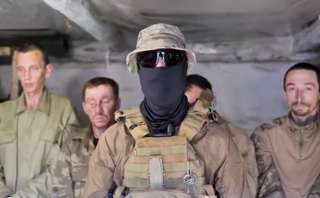 Ukrainas aizstāvis (priekšplānā) ar sagūstītajiem krievu iebrucējiem.