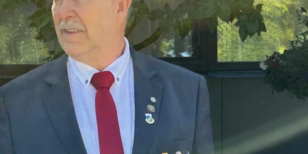 Ķekavas novada deputāts Andis Adats pozē ar padomju Latvijas nozīmīti uz krūtīm.