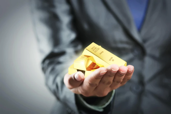 Four golden bars on theZelta cena 2025. gada vidū sasniegusi vēsturiskus rekordus. Pašlaik viena Trojas unce (31,1 g) maksā aptuveni 3500 ASV dolāru (3015 eiro). Tas ir gandrīz divreiz vairāk nekā 2020. gadā. woman's hand