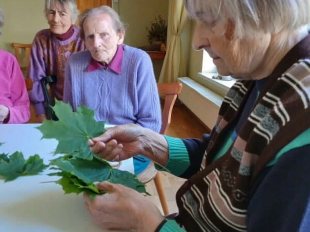Agnese Podiņa (priekšplānā) nupat iemācījusies no kļavu lapām izveidot paplāti Jāņu sieram.