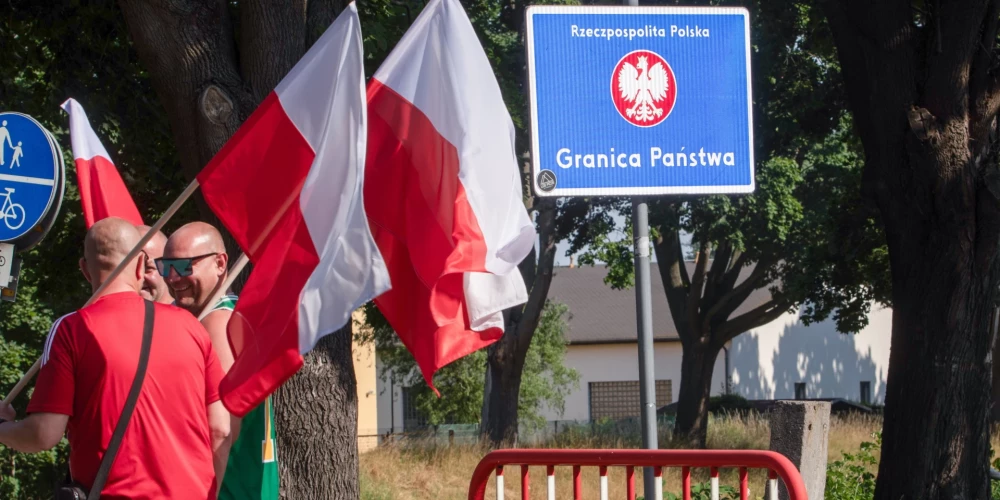 Cilvēki piedalās piketā, lai iebilstu pret migrantu atgriešanu, Polijas dienvidrietumos, 2025. gada 3. jūlijā.